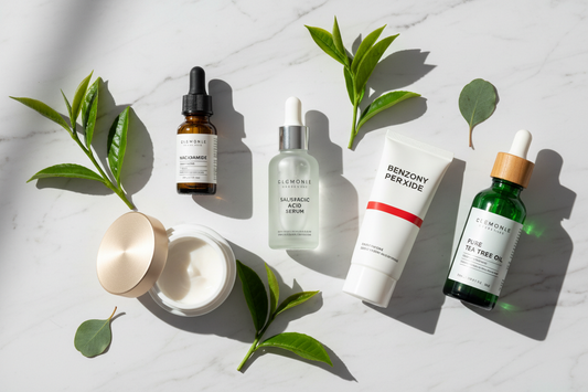 Best acne-fighting skincare ingredients including salicylic acid, niacinamide, retinol, and tea tree oil arranged on white marble surface - dermatologist-recommended products for clear skin